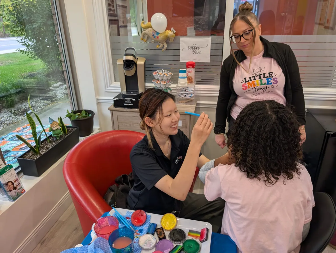 Heartland team member painting a child's face at the Little Smiles face-painting table