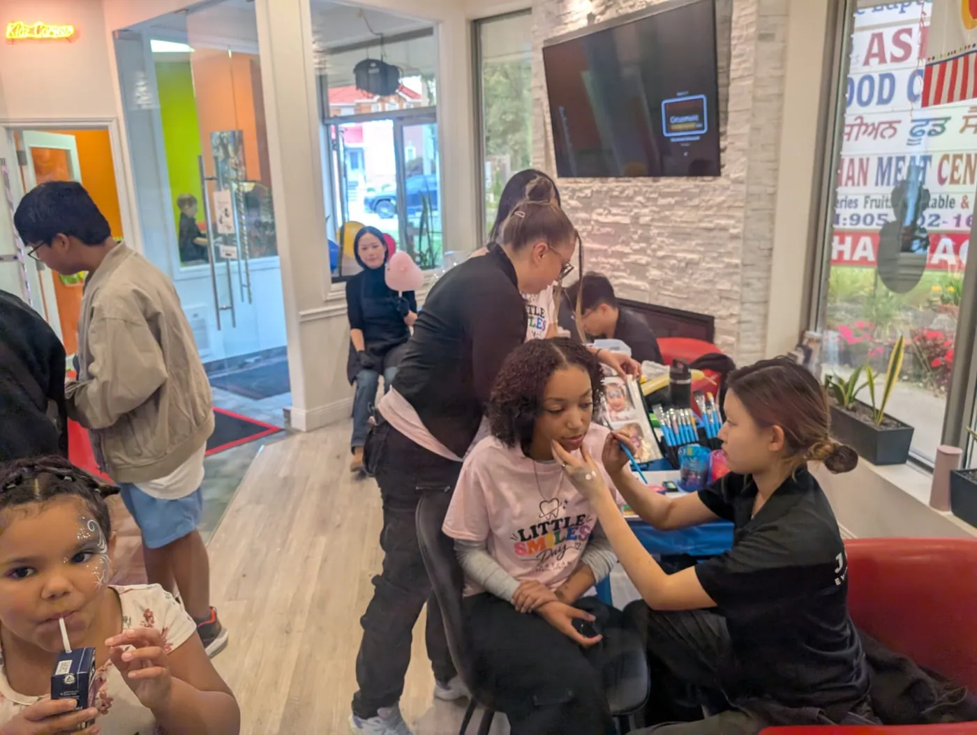 Families and team members enjoying face painting and activities in the Heartland waiting area